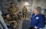 A New Hampshire Army National Guard dental team confers with Andrea Iasillo of the Manchester Health Department in a mobile dental clinic Jan. 7, 2023, at Beech Street Elementary School. From left are Spc. Hayley Minahan, Lt. Col. Christopher Fauver, Sgt. Katie Lindh, and Maj. Jacob Ayers.