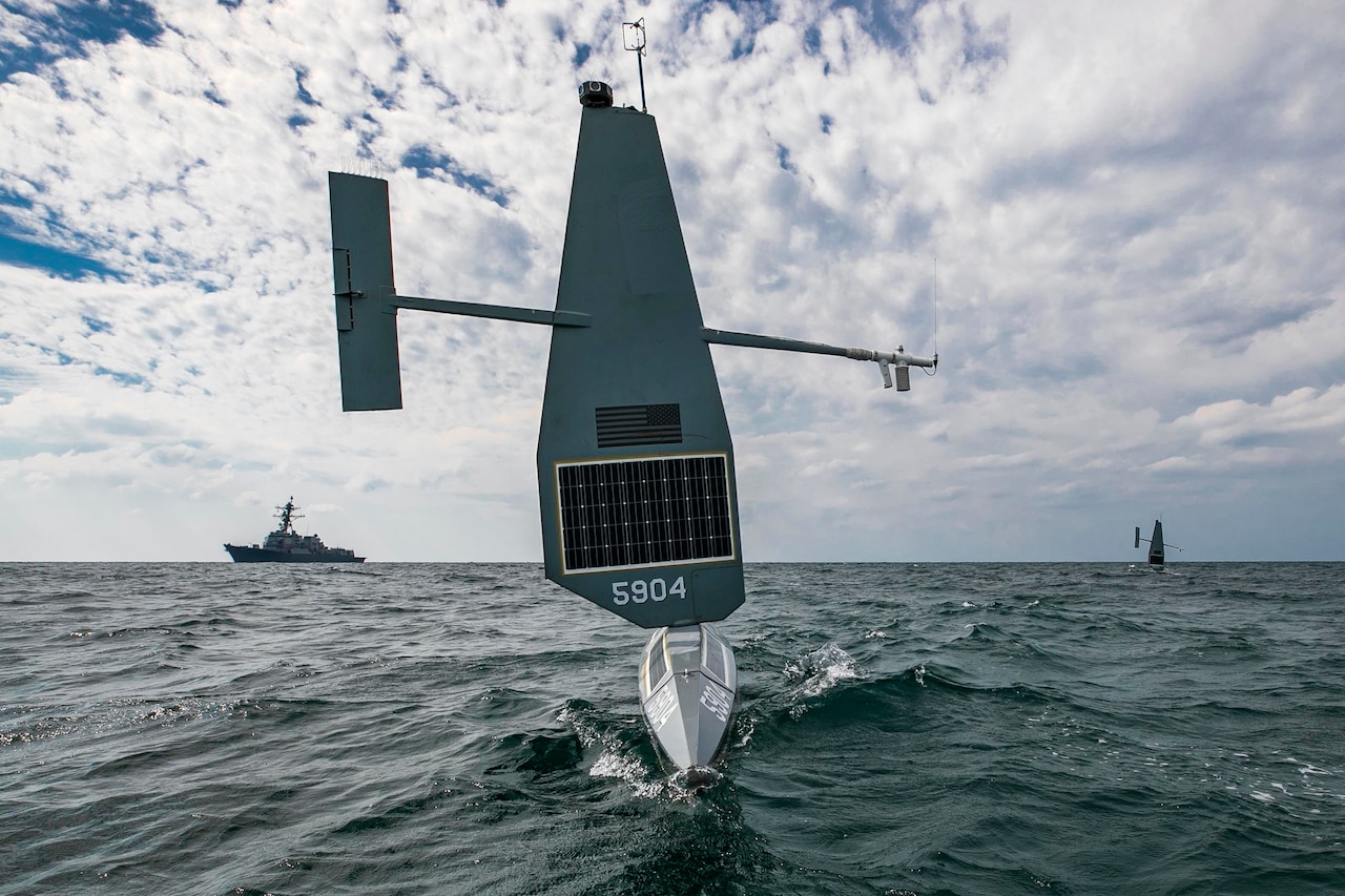 Three military vessels operate in the water.