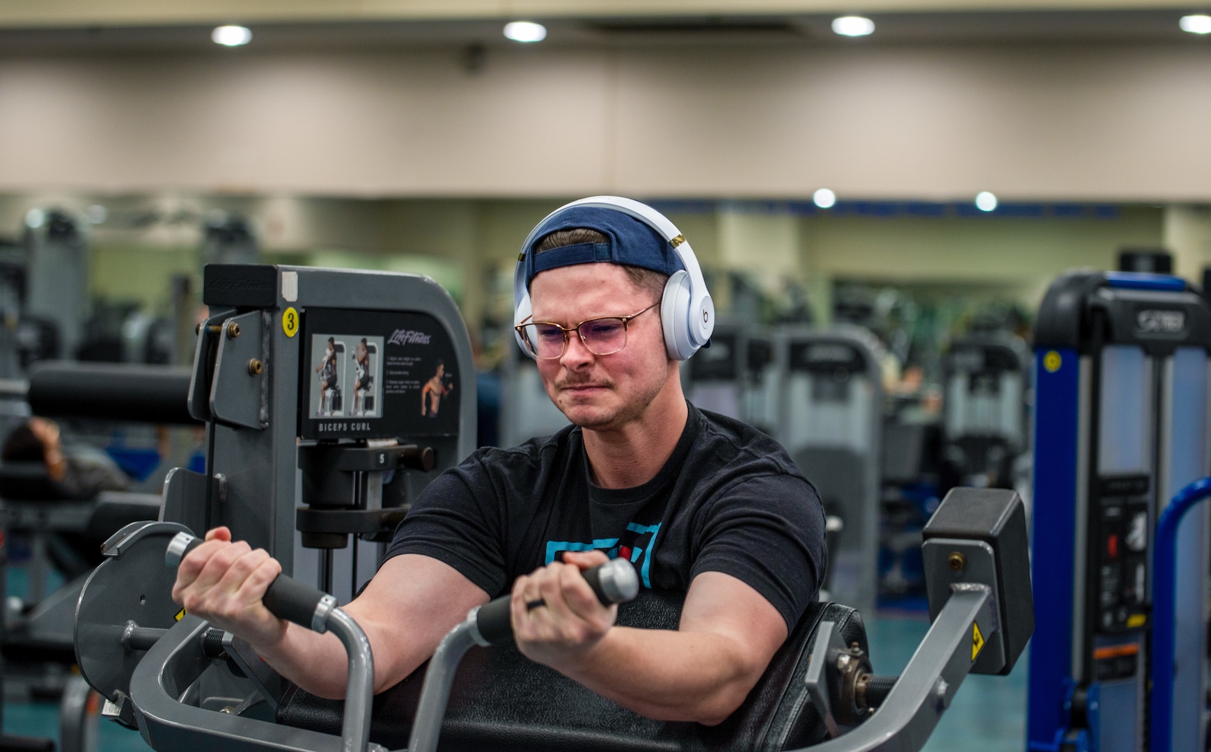 U.S. Air Force Airman 1st Class Aaron Edwards, 51st Fighter Wing public affairs specialist performs preacher curls during a back and bicep workout at the fitness center on Osan Air Base, Republic of Korea, Dec. 30, 2022. Edwards uses weight lifting and physical activity to improve his physique and relieve stress. (U.S. Air Force Photo by Staff Sgt. Dwane Young)