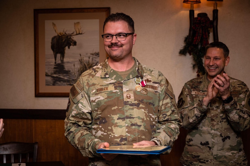 Man stands holding award