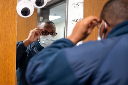 U.S. Coast Guard Petty Officer 3rd Class Anthony Anyaka tries on a pair of glasses at Joint Base Anacostia-Bolling, Washington, D.C., Oct. 5, 2022. The 316th Medical Squadron Optometry Clinic provides prescription eyeglasses for active duty and retired active duty service members across the National Capital Region. (U.S. Air Force photo by Kristen Wong)