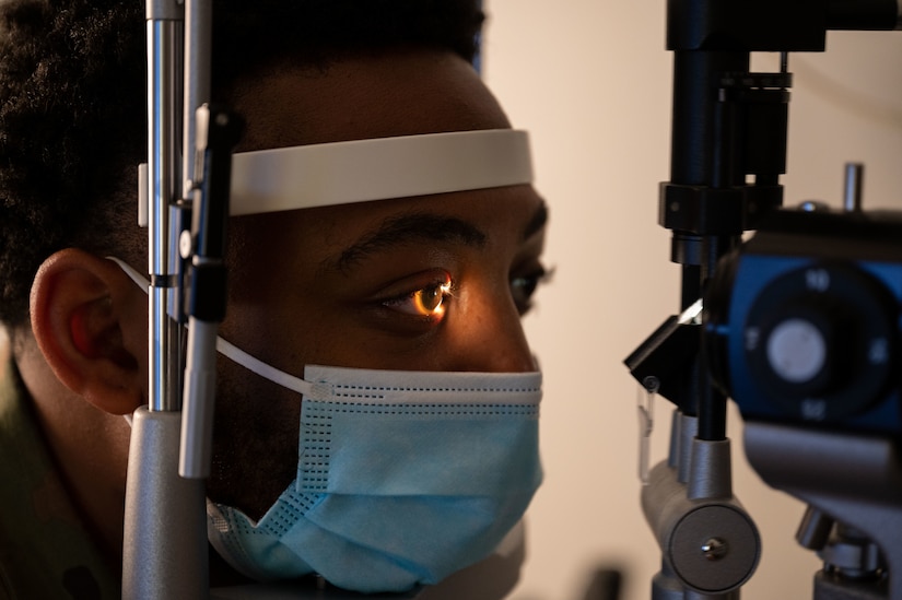 U.S. Air Force Staff Sgt. James Flowers, 11th Civil Engineer Squadron, has his eye examined with a slit lamp during a routine eye examination at Joint Base Anacostia-Bolling, Washington, D.C., Oct. 5, 2022. The 316th Medical Squadron Optometry Clinic provides comprehensive primary eye care for service members across the National Capital Region. (U.S. Air Force photo by Kristen Wong)