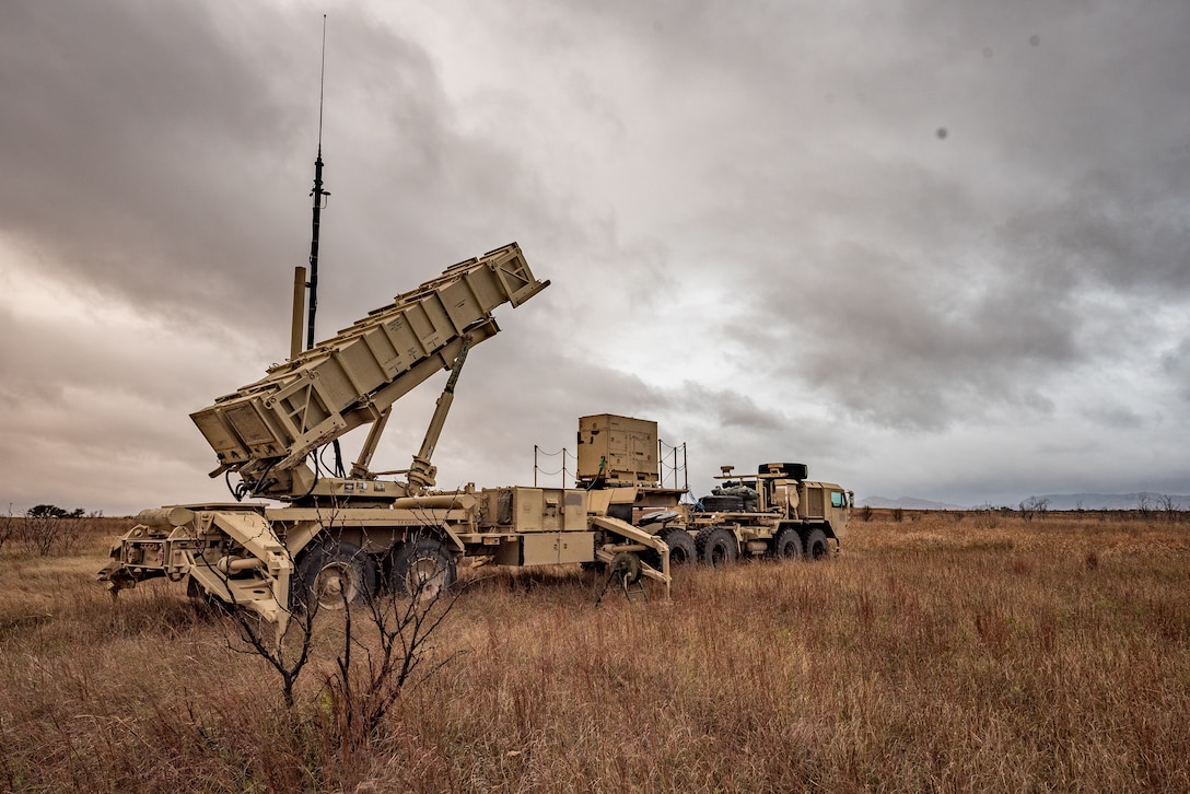 A large piece of military hardware sits in a field.