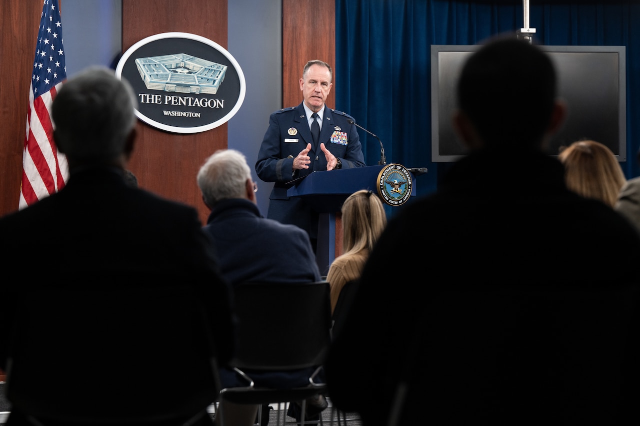 A man speaks to an audience from the podium.