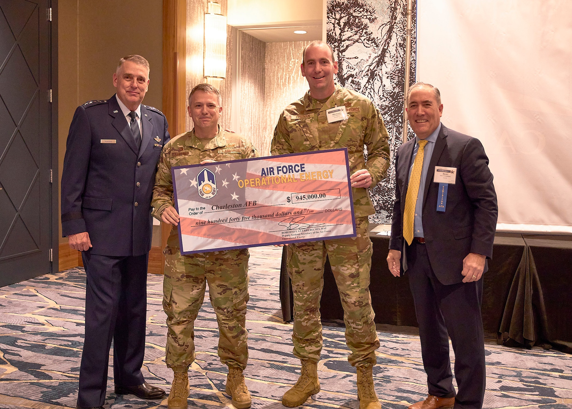 (From left) Commander of Air Mobility Command Gen. Mike Minihan, commander of the 60th Air Mobility Wing, Col. Derek M. Salmi, and Deputy Assistant Secretary of Air Force Operational Energy, Roberto Guerrero, pose for a photo after the Mission Execution Excellence Program award ceremony at the Airlift Tanker Association Symposium on October 26, 2022, in Denver, Colorado. (Airlift Tanker Association photo)