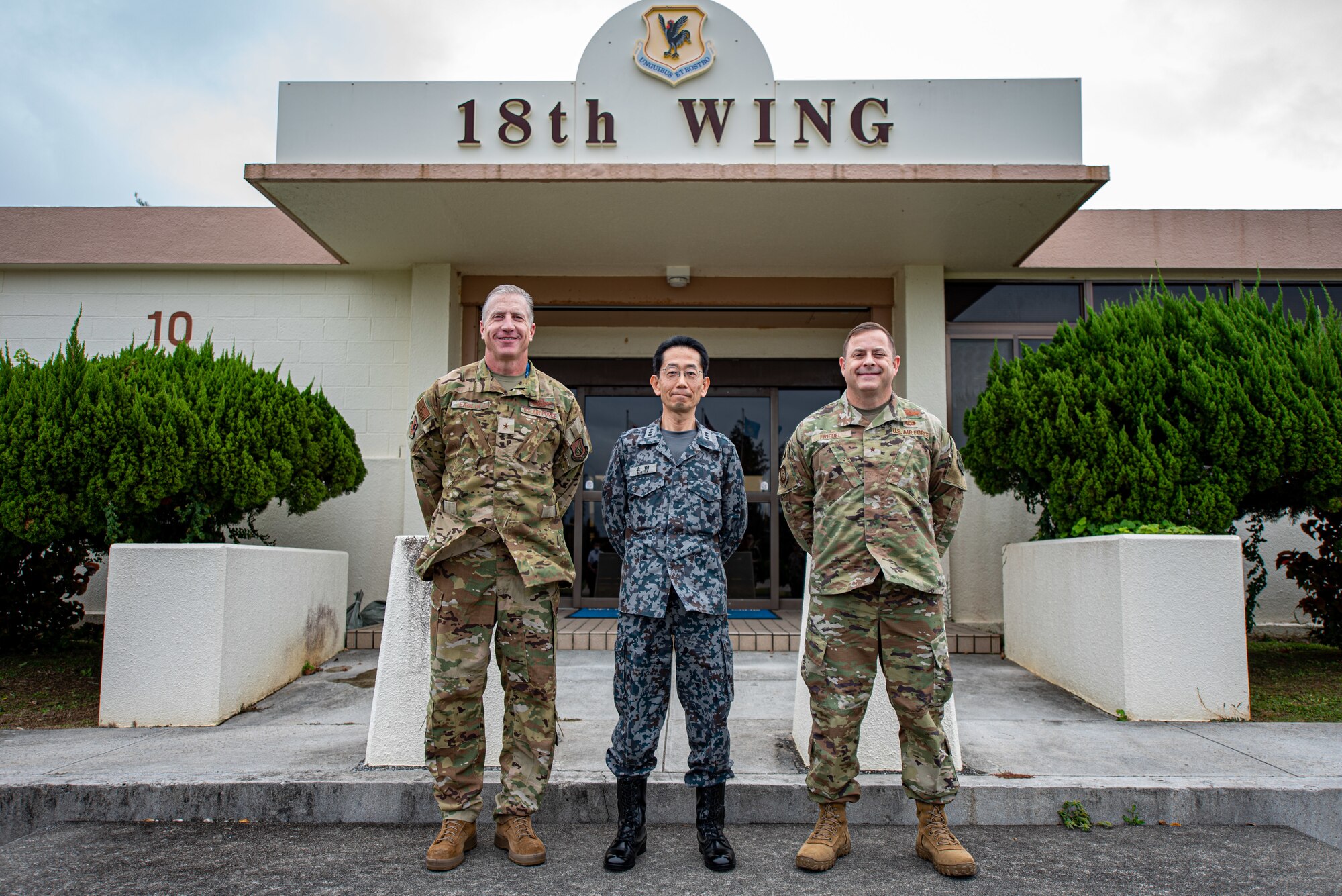 Airmen and a Japanese service member pose for a picture.