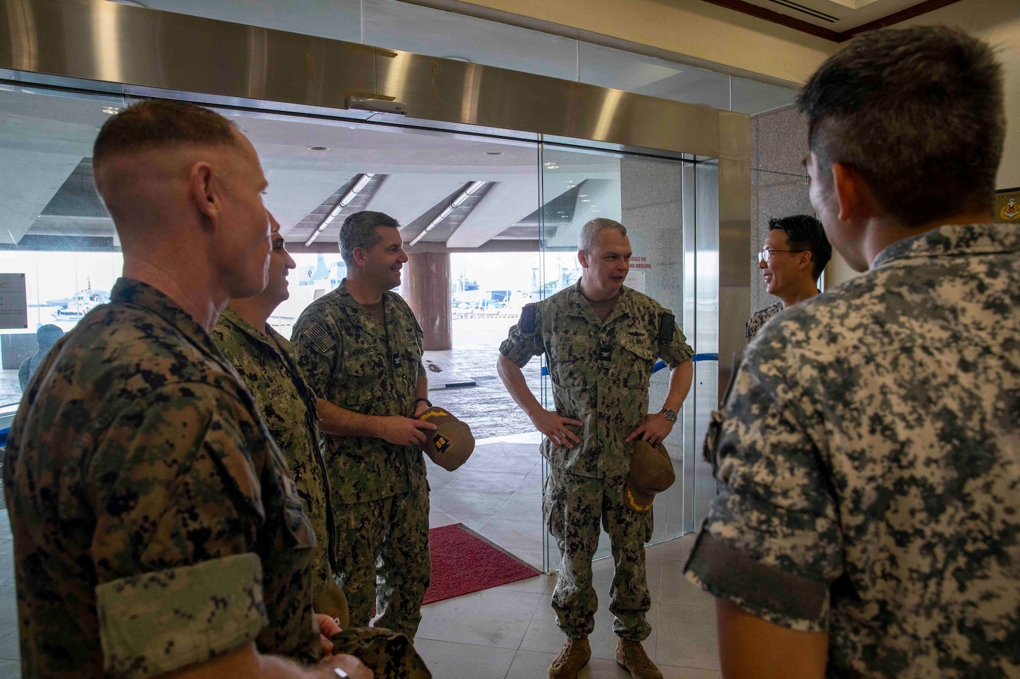 SINGAPORE (Jan. 9, 2023) Capt. Justin Kubu, commodore of Amphibious Squadron SEVEN, center right, and Capt. Doug Langenberg, commanding officer of USS John P. Murtha (LPD 26), speak to commanders of the Republic of Singapore Navy prior to the opening ceremony of Cooperation Afloat Readiness and Training (CARAT)/Marine Exercise (MAREX) Singapore 2022, Jan. 9, 2023. CARAT Singapore is a bilateral exercise between Singapore and the United States designed to promote regional security cooperation, maintain and strengthen maritime partnerships, and enhance maritime cooperation. In its 28th, the CARAT series is comprised of multinational exercises, designed to enhance U.S. and partner forces’ abilities to operate together in response to traditional and non-traditional maritime security challenges in the Indo-Pacific region. The Makin Island Amphibious Ready Group, comprised of amphibious assault ship USS Makin Island (LHD 8) and amphibious transport dock USS Anchorage (LPD 23) and USS John P. Murtha (LPD 26), is operating in the U.S. 7th Fleet area of operations with the embarked 13th Marine Expeditionary Unit to enhance interoperability with Allies and partners and serve as a ready-response force to defend peace and maintain stability in the Indo-Pacific region. (U.S. Navy photo by Mass Communication Specialist 3rd Class Kendra Helmbrecht)