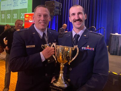 Capt. (Dr.) Robert Brooks, left, and Maj. (Dr.) Kent Miller, right, allergy and immunology fellows, pose for a photo with their 2022 Fellows in Training Bowl trophy in Louisville, Kentucky, Nov. 22, 2022.