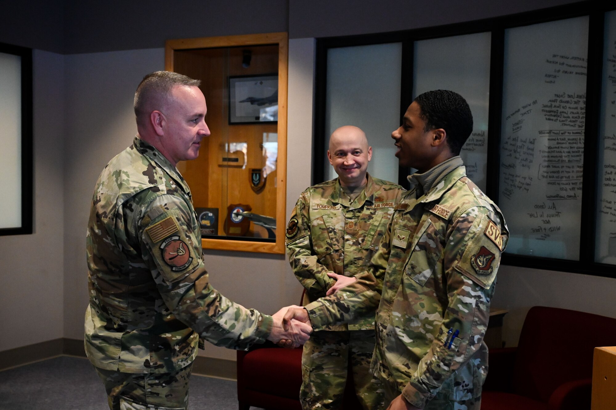 U.S. Air Force Chief Master Sgt. David R. Wolfe, the Pacific Air Forces command chief, coins Airman 1st Class Derek Clayborne, a 354th Force Support Squadron storeroom clerk, during a base visit at Eielson Air Force Base, Alaska, Jan. 4, 2023.
