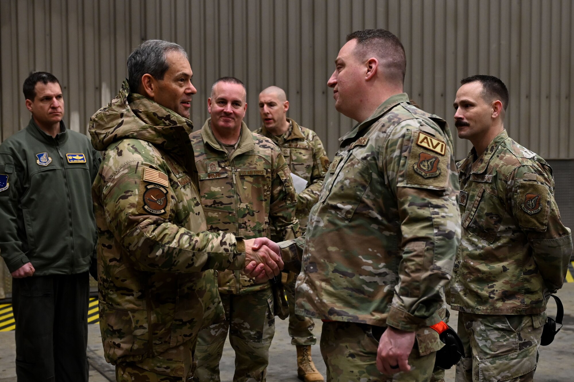 U.S. Air Force Gen. Ken Wilsbach, the Pacific Air Forces commander, coins Master Sgt. Christopher Blake, the 354th Aircraft Maintenance Squadron F-16 production superintendent, during a base visit at Eielson Air Force Base, Alaska, Jan. 4, 2023.