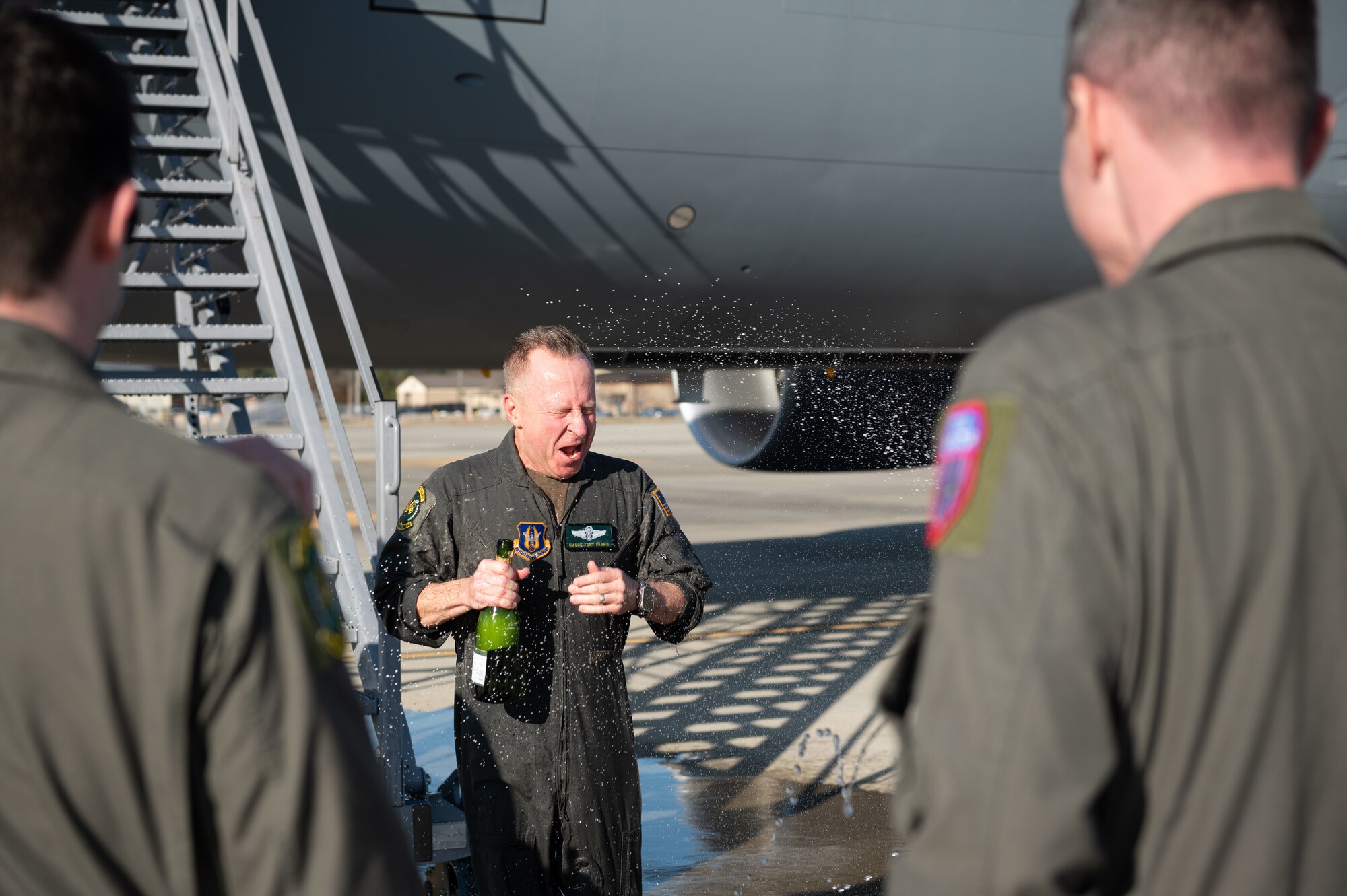 Chief Master Sgt. Tony Parris, 77th Air Refueling Squadron boom operator, gets drenched with water and champagne after his fini flight at Seymour Johnson Air Force Base, North Carolina, Jan. 5, 2023. The final flight, or fini flight, is a tradition among pilots and air crew to celebrate one’s last flight with their unit or on a certain airframe. (U.S. Air Force Photo by Airman 1st Class Rebecca Sirimarco-Lang)
