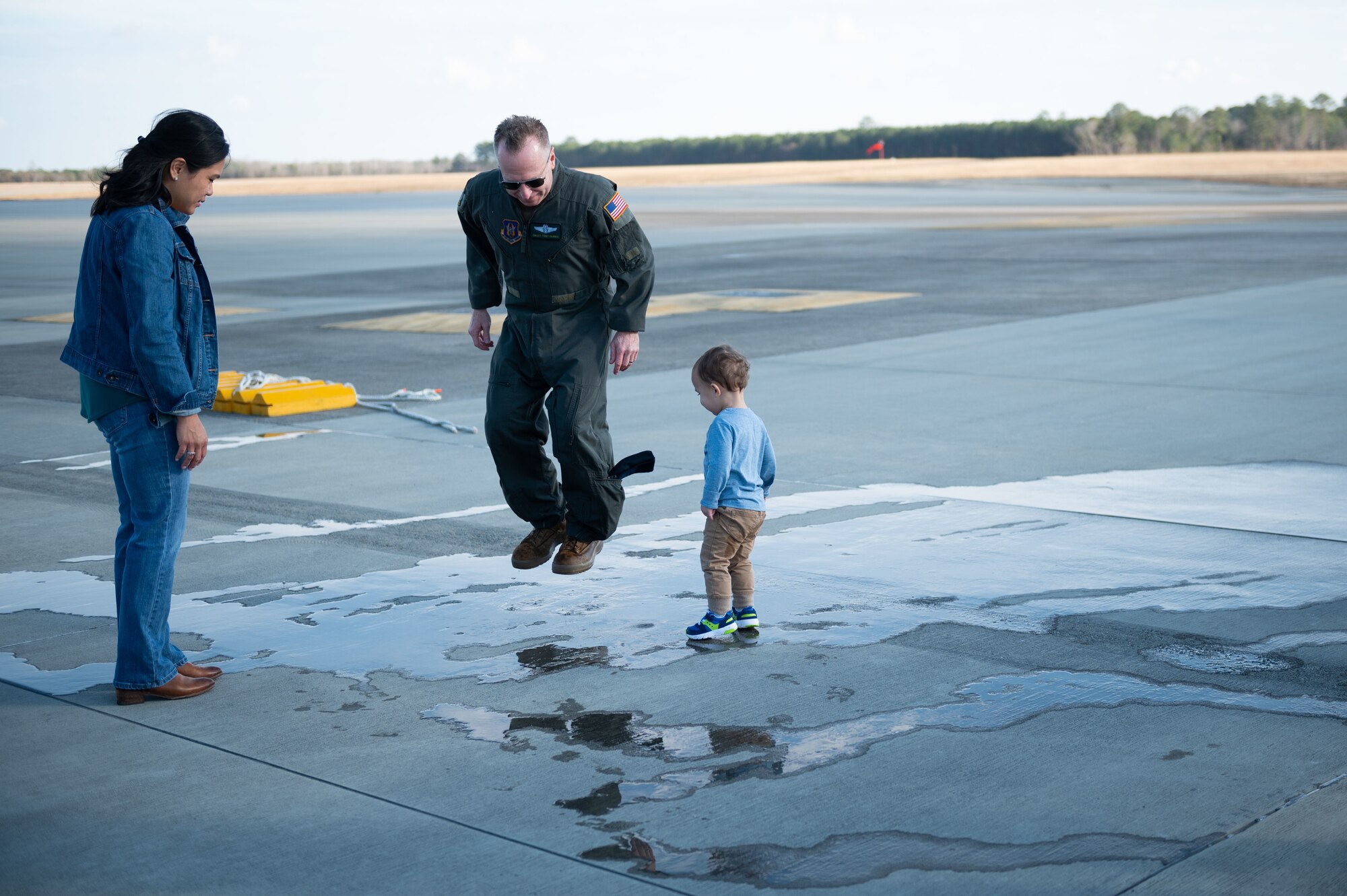 Chief Master Sgt. Tony Parris, 77th Air Refueling Squadron boom operator, and his son, play in water after his fini flight at Seymour Johnson Air Force Base, North Carolina, Jan. 5, 2023. The final flight, or fini flight, is a tradition among pilots and air crew to celebrate one’s last flight with their unit or on a certain airframe. (U.S. Air Force Photo by Airman 1st Class Rebecca Sirimarco-Lang)