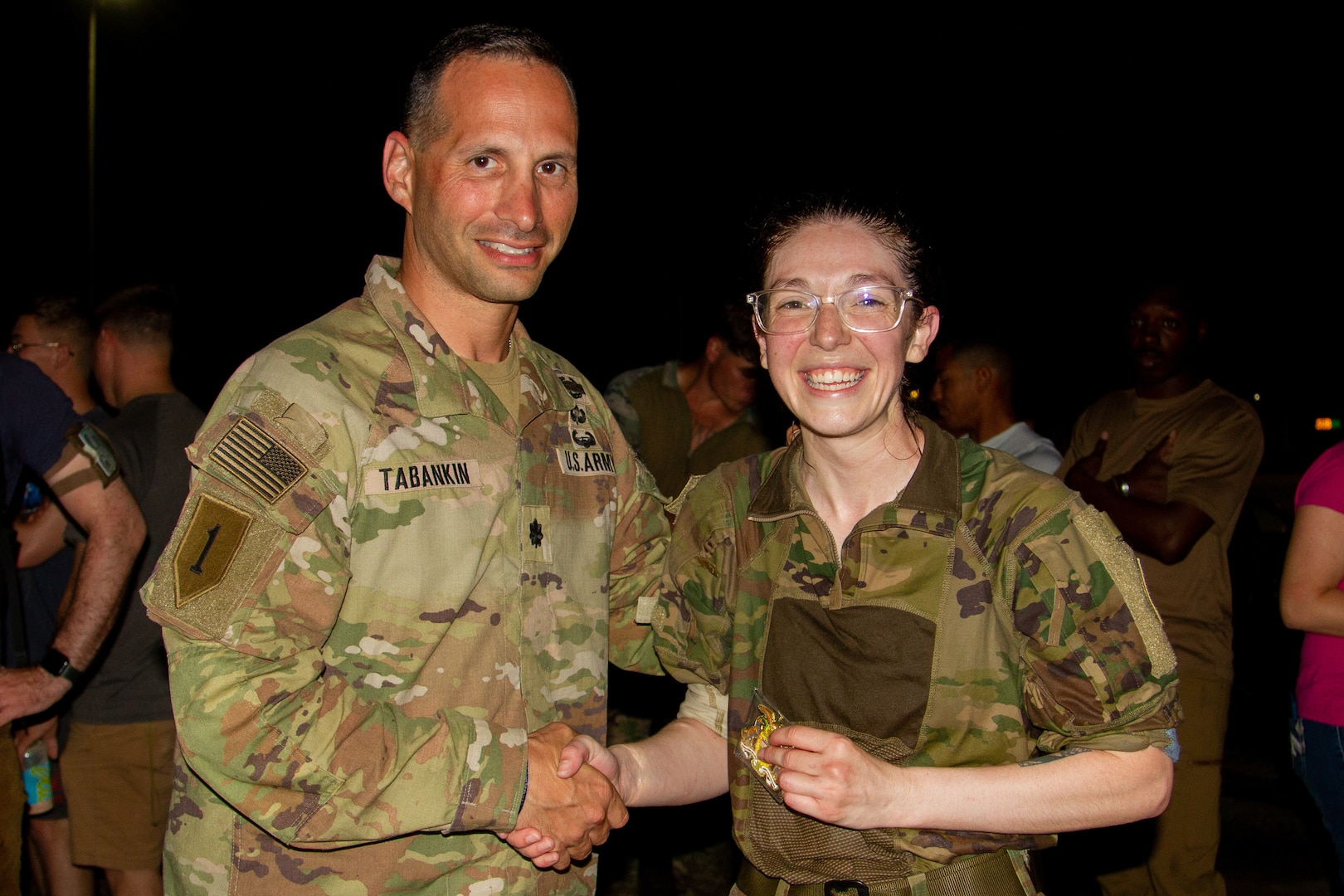 U.S. Army Lt. Col. Shawn Tabankin, commander of 1st Battalion, 69th Infantry Regiment, presents a challenge coin to Capt. Nina Skinner, a communications officer with 1st Battalion, 69th Infantry Regiment, after she completed a Norwegian Foot March at Camp Lemonnier, Djibouti, Dec. 16, 2022. Skinner placed first among the female participants with a finish time of 3 hours and 59 minutes.