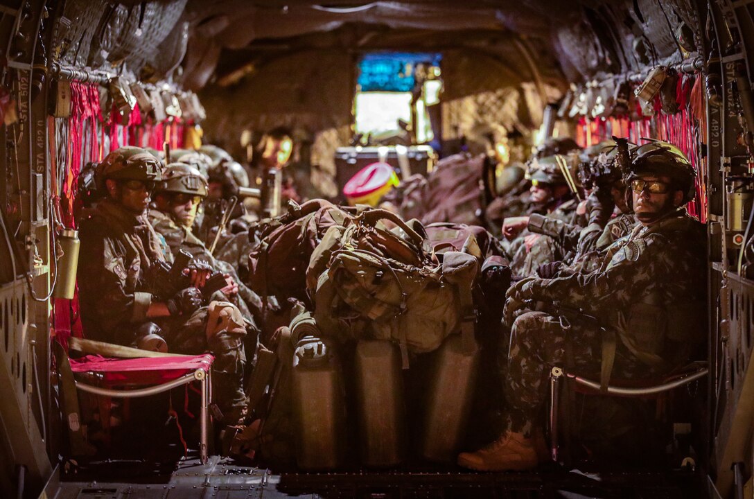 Soldiers and the Brazilian army prepare to travel in CH-47 Chinook helicopters in preparation to fly out to the training area of the Joint Readiness Training Center August 12, 2022.