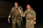 U.S. Army Sgt. Jonathan Licurse, a petroleum supply specialist assigned to Company D, 1st Battalion, 69th Infantry Regiment, and 1st Sgt. Jeffrey Dorvee, the senior enlisted leader of Company D, 1st Battalion, 69th Infantry Regiment, fist-bump during a Norwegian Foot March at Camp Lemonnier, Djibouti, Dec. 16, 2022. Participants were required to ruck 18.6 miles while carrying 25 pounds of dry weight.