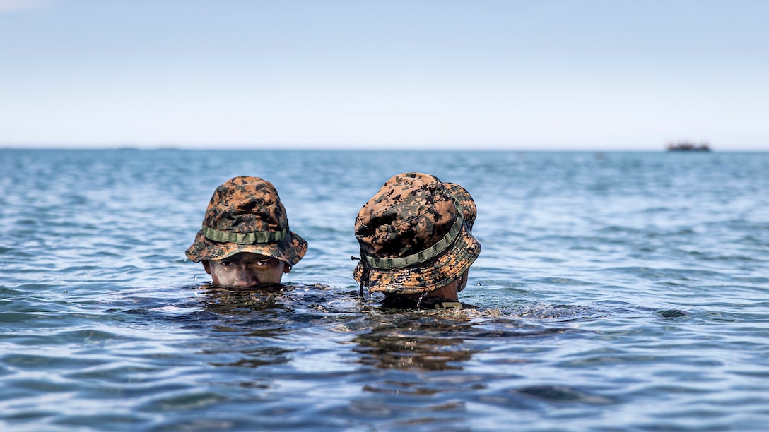 U.S. Marine Corps Lance Cpl. Kody Morgan, left, swims ashore as Cpl. Salahudeen Rammouz, right, both scout swimmers with Battalion Landing Team 2/5, 31st Marine Expeditionary Unit, relays instructions off the coast of Naval Education, Training, and Doctrine Command, Zambales, Philippines, Oct. 6, 2022, during a rehearsal. The rehearsal is in preparation for a bilateral amphibious landing demonstration. KAMANDAG is an annual bilateral exercise between the Armed Forces of the Philippines and U.S. military designed to strengthen interoperability, capabilities, trust, and cooperation built over decades shared experiences.