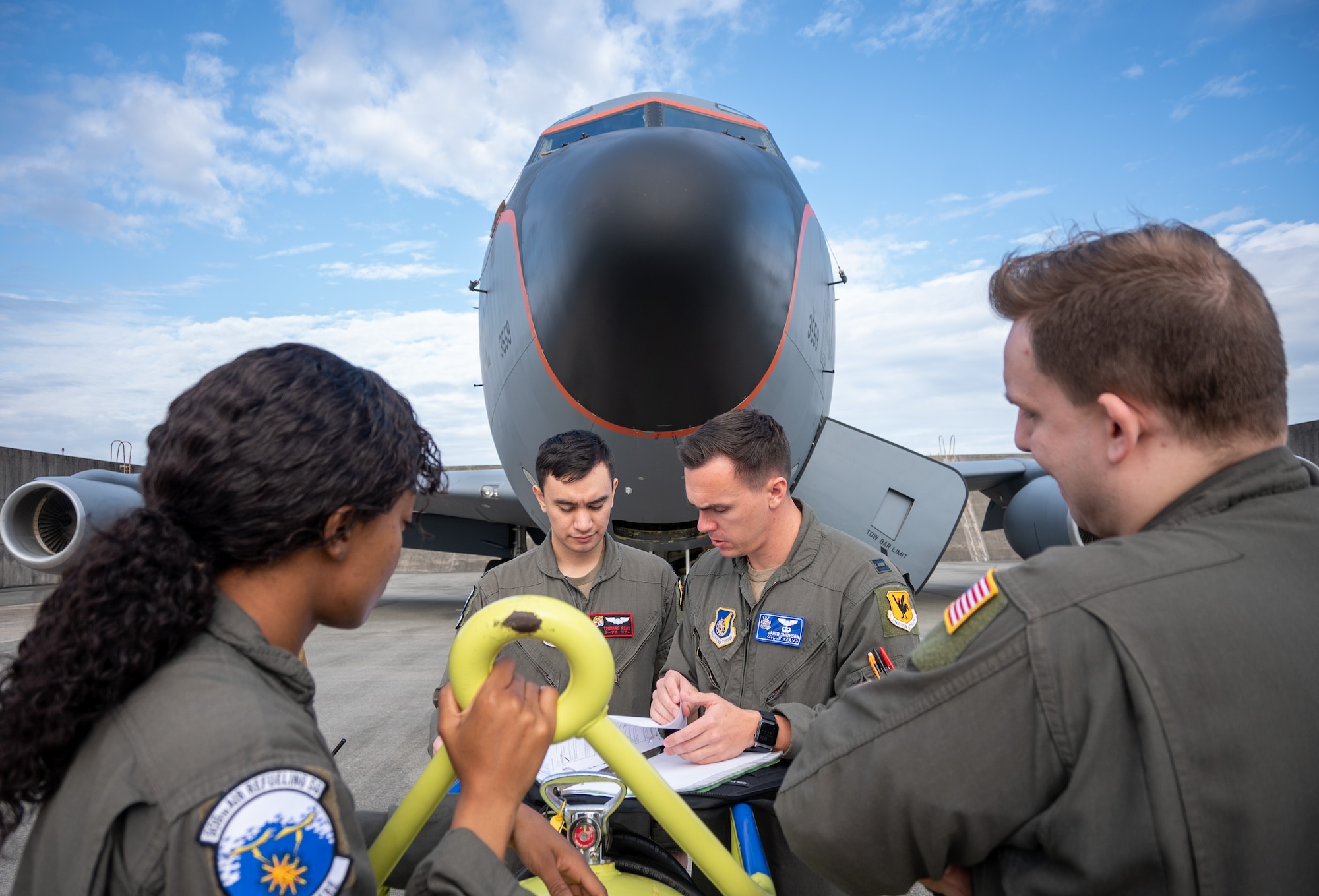 Aircrew review paperwork in front of an aircraft