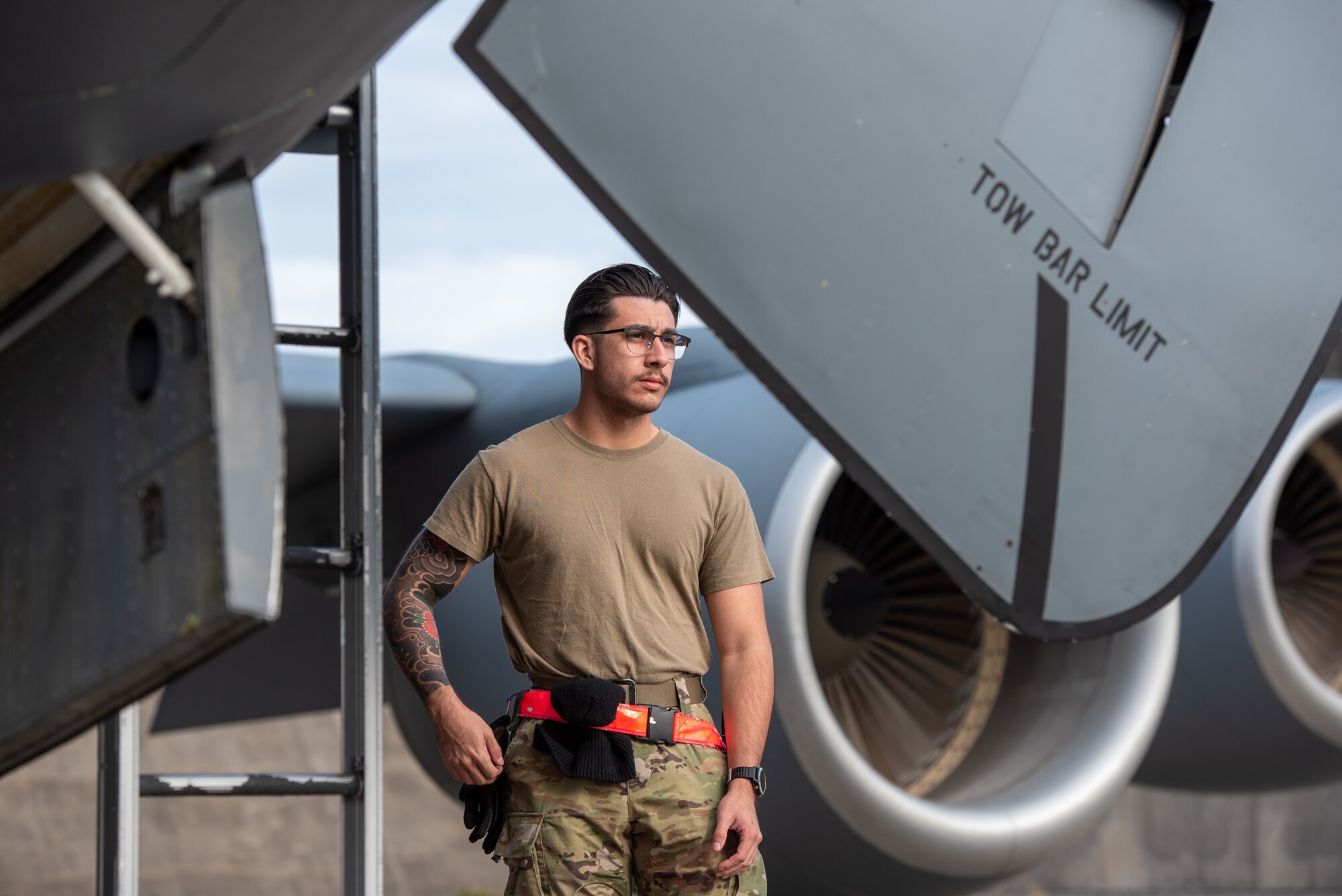 Airman stands next to an aircraft