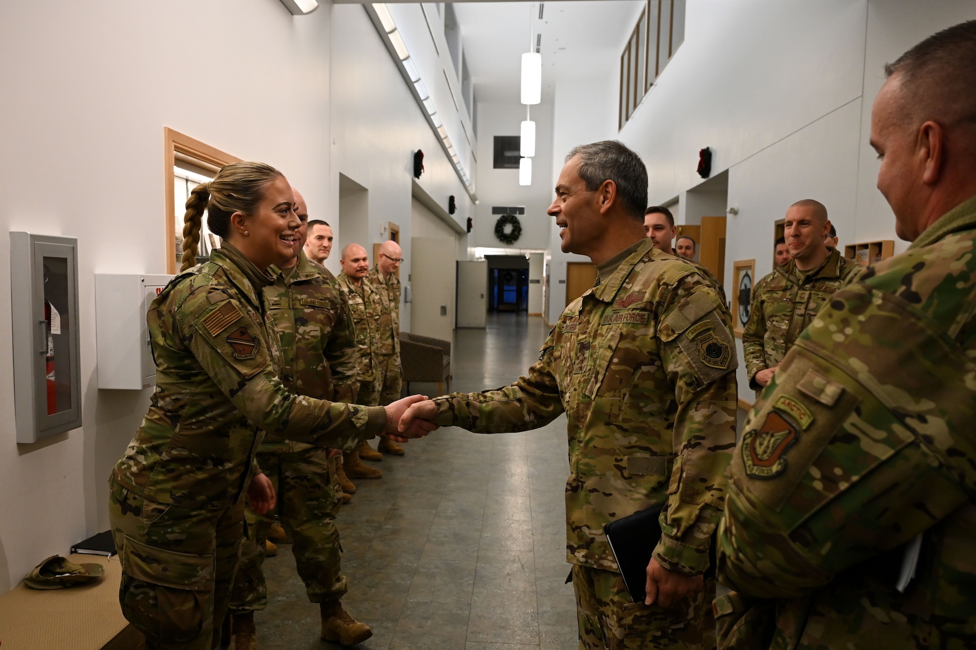 U.S. Air Force Gen. Ken Wilsbach, the Pacific Air Forces commander (right), coins Staff Sgt. Katherine Savvidis, the 354th Medical Group noncommissioned officer in charge of commander support staff, during a base visit at Eielson Air Force Base, Alaska, Jan. 4, 2023.