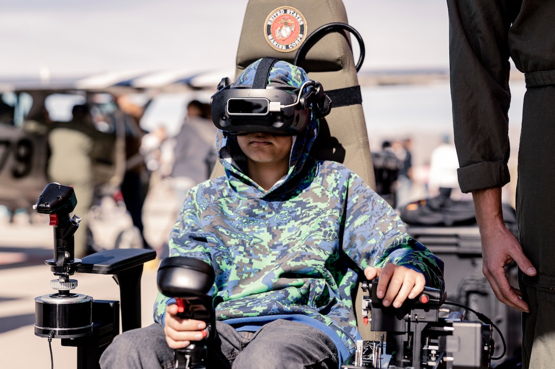 An attendee of Aviation Nation participates in a Marine Corps flight simulator at Nellis Air Force Base, North Las Vegas, Nev., Nov. 5, 2022. Recruiters with Recruiting Station Salt Lake City attended the Aviation Nation Air Show on November 5th and 6th where they set up “Battle Positions,” a flight simulator, and a pull-up challenge. (U.S. Marine Corps photo by Cpl. Lydia Gordon)