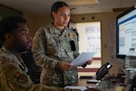 Photo of two Airmen examining patient records using the MHS Genesis system.