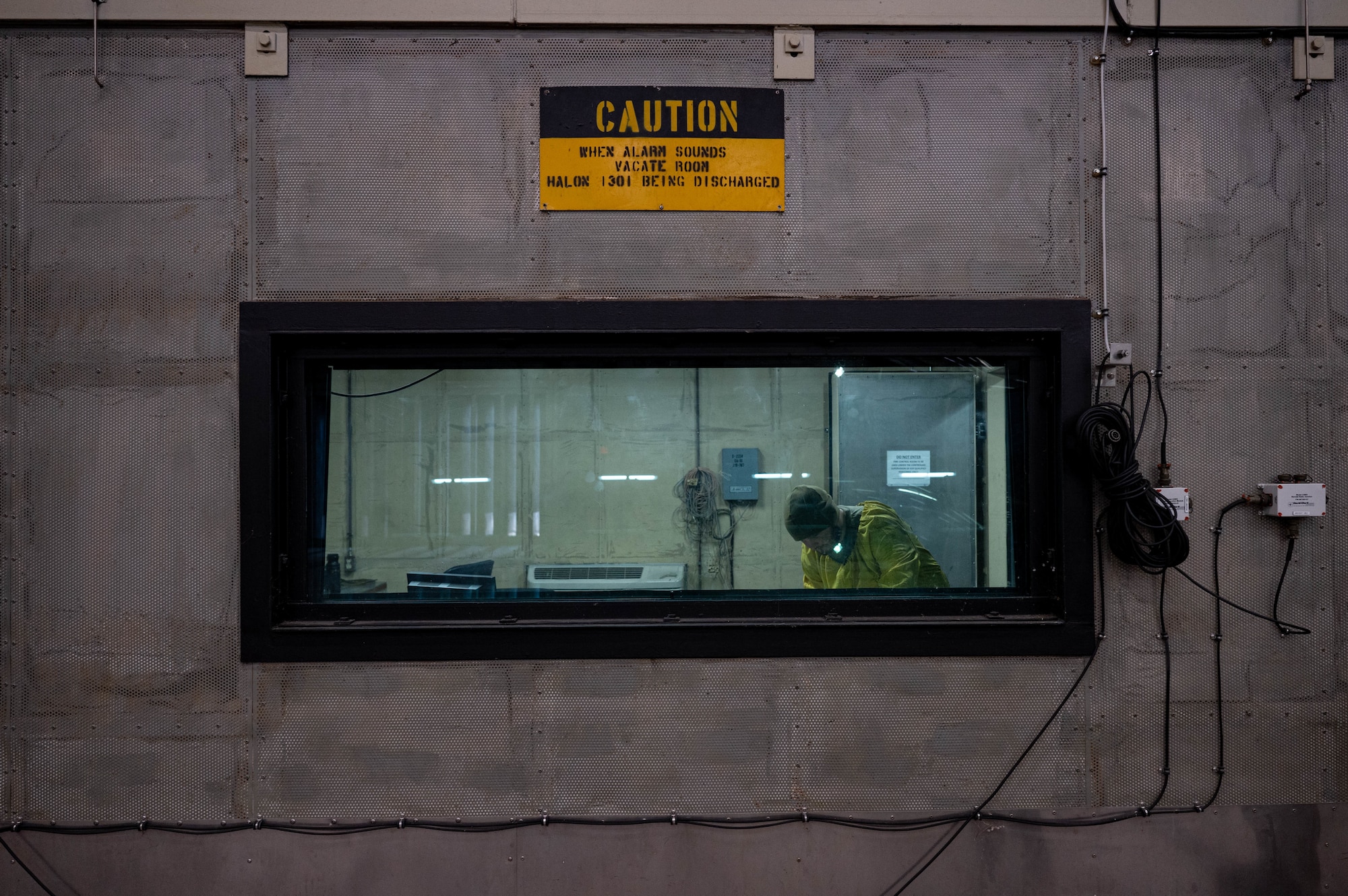 Staff Sgt. Zachary Lester, 8th Maintenance Squadron aerospace propulsion craftsman, stands in a secure room inside the ‘Hush House’ at Kunsan Air Base, Republic of Korea, Jan. 9, 2023. Additional support Airmen are always present during the testing of an engine or aircraft in the Hush House to ensure mission safety requirements. (U.S. Air Force Photo by Senior Airman Shannon Braaten)