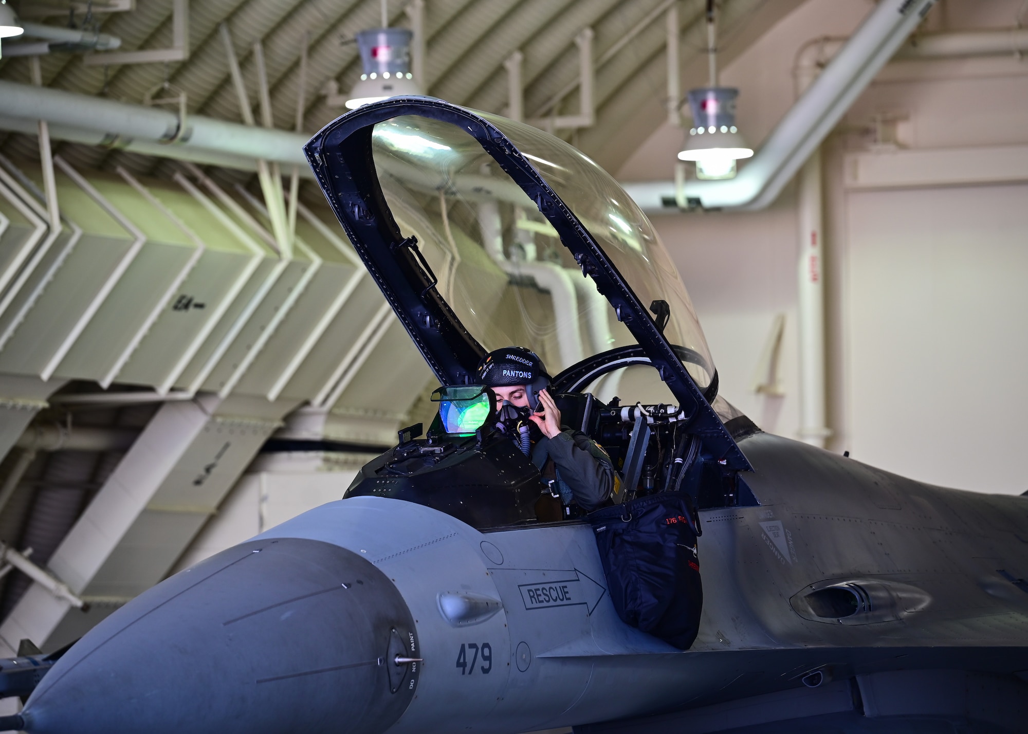Pilot dons his helmet.