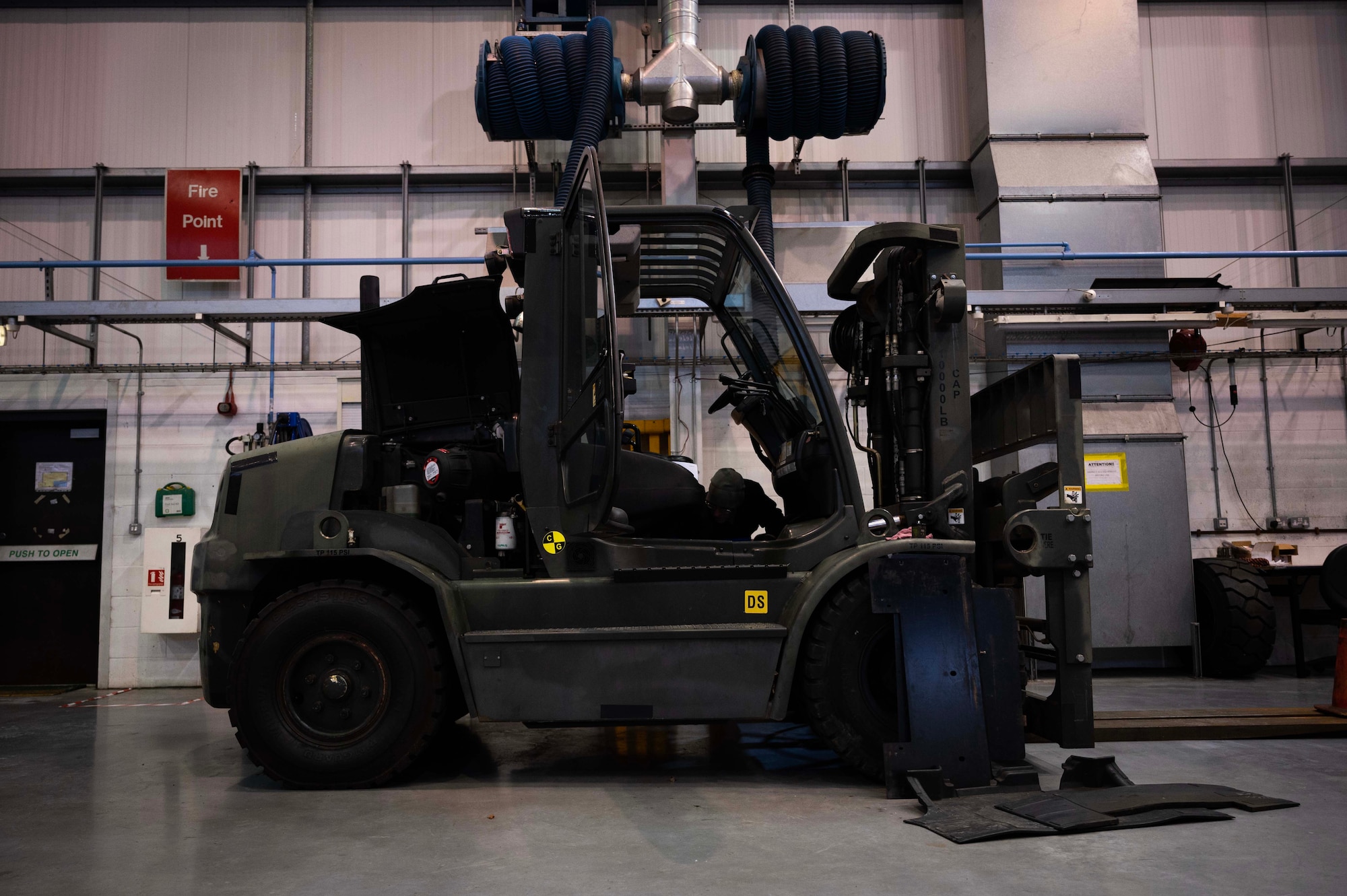 A cargo forklift undergoes electrical repair at Royal Air Force Mildenhall, England, Jan. 9, 2023. The forklift can lift up to 10,000 pounds which is essential to aircraft missions and personnel movement. (U.S. Air Force photo by Airman 1st Class Viviam Chiu)
