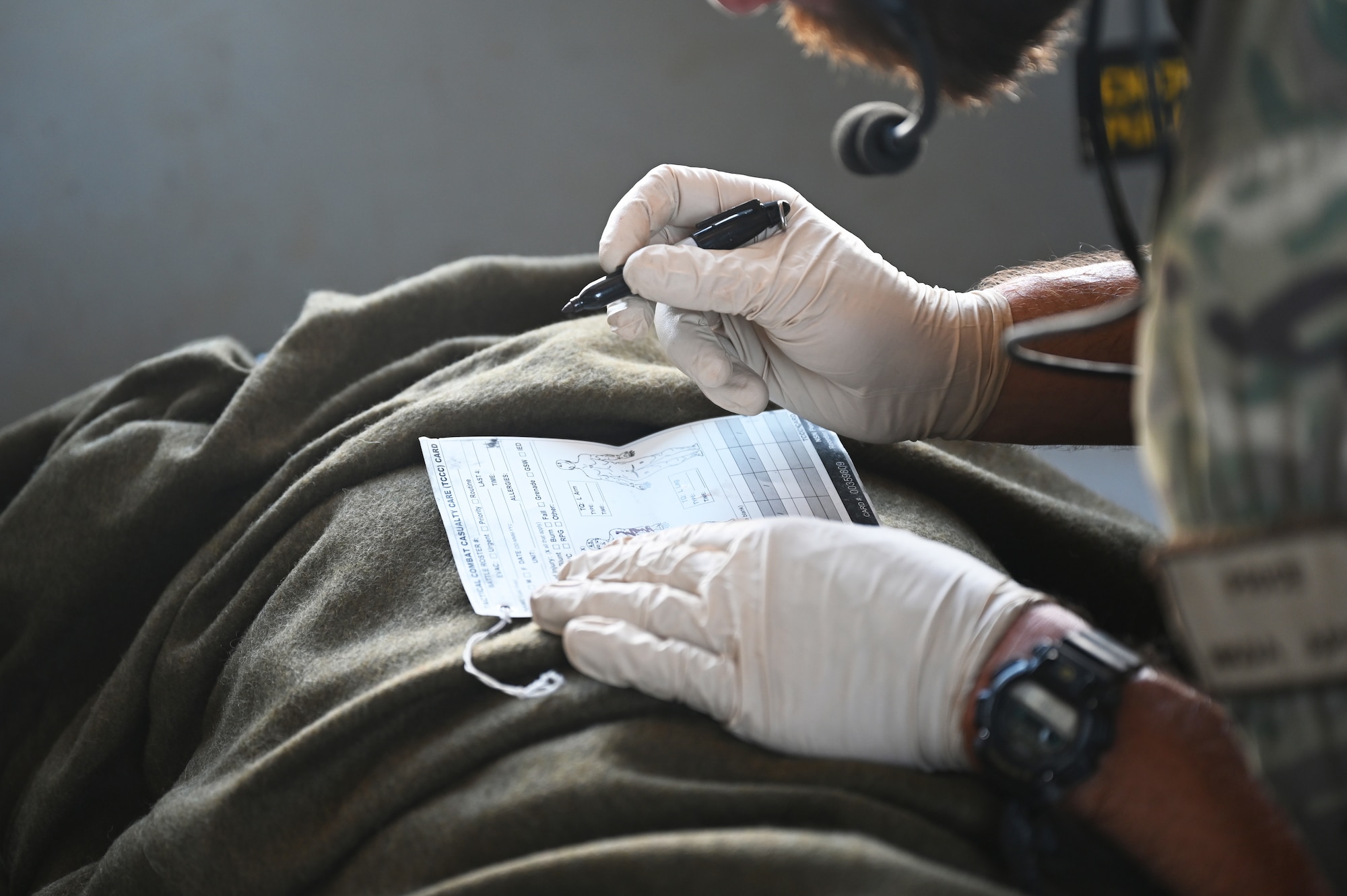 A U.S. Pararescueman fills out a report concerning a simulated casualty aboard a HH-60W combat rescue helicopter during a casualty evacuation (CASEVAC) exercise at an undisclosed Combined Joint Task Force-Horn of Africa area of responsibility, Dec 8, 2022.