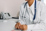 A doctor sits at a desk