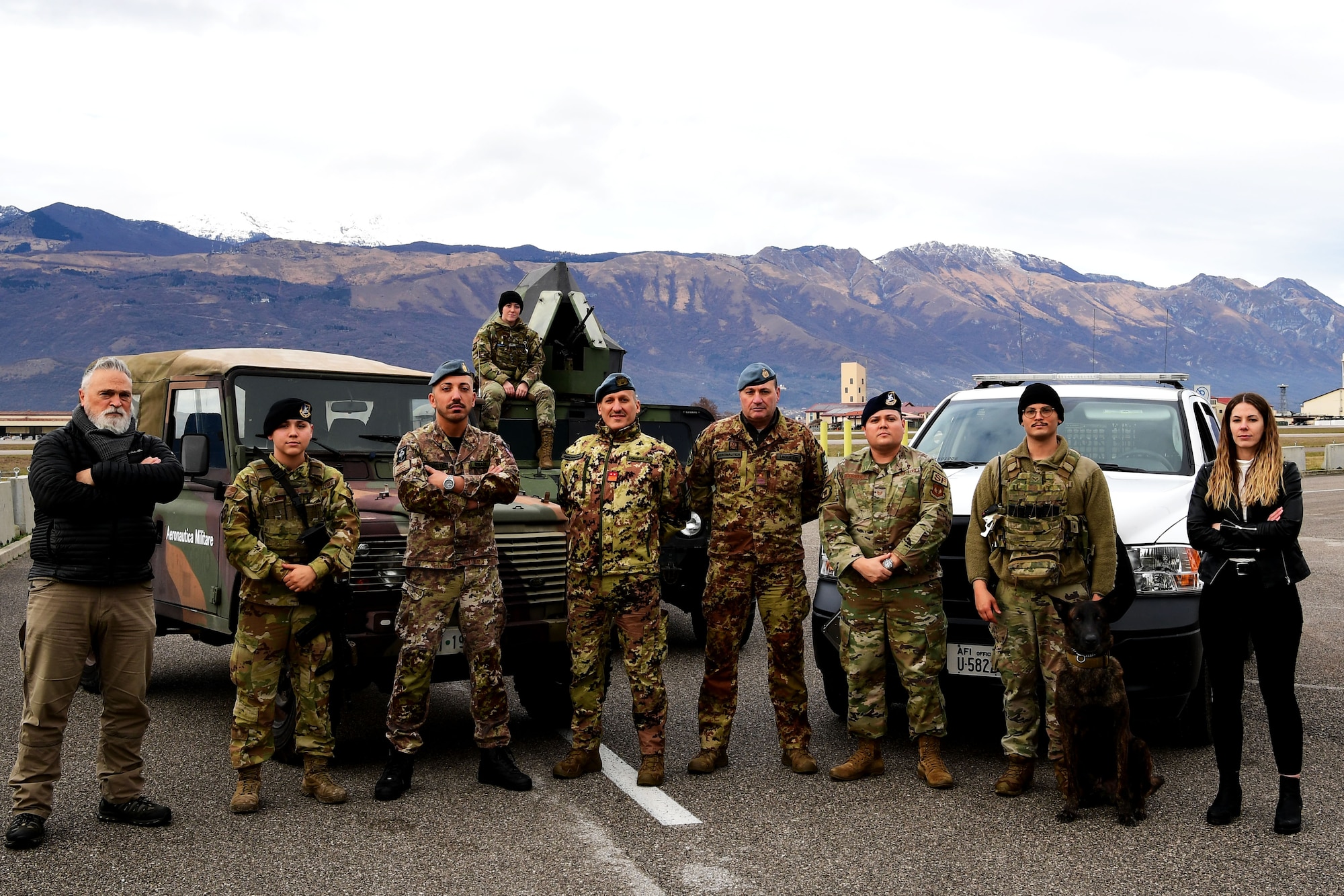 Members from the 31st Fighter Wing Anti-Terrorism office, 31st Security Forces military working dog handler and dog, 31st Security Forces Squadron and Italian Air Force Security personnel pose for a photo at Aviano Air Base, Italy, Jan. 12, 2023. Aviano Anti-Terrorism is a joint effort across multiple squadrons, units and our NATO Allies. (U.S. Air Force photo by Senior Airman Noah Sudolcan)