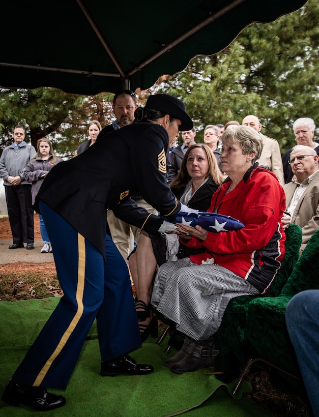 Army 1st Sgt. Naarah Stallard presents a folded flag to Paulette Ross, daughter of Master Sgt. Wilma Ross, a retiree of the Kentucky Army National Guard at the Grove Hill Cemetery in Shelbyville, Ky. on Dec. 9, 2022. Wilma Ross retired after 24 years of service and passed away at the age of 81. (U.S. Army photo by Andy Dickson)