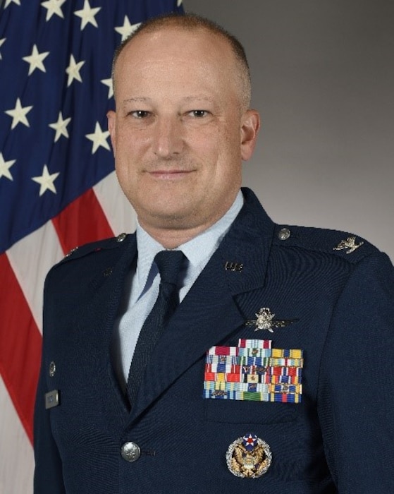 An official photo of a man wearing a blue dress uniform.