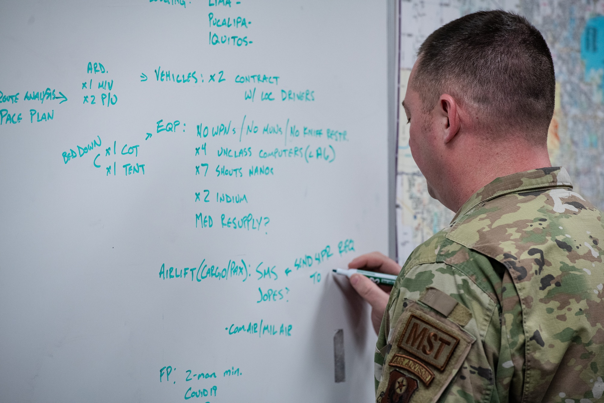 an airman writes on a whiteboard