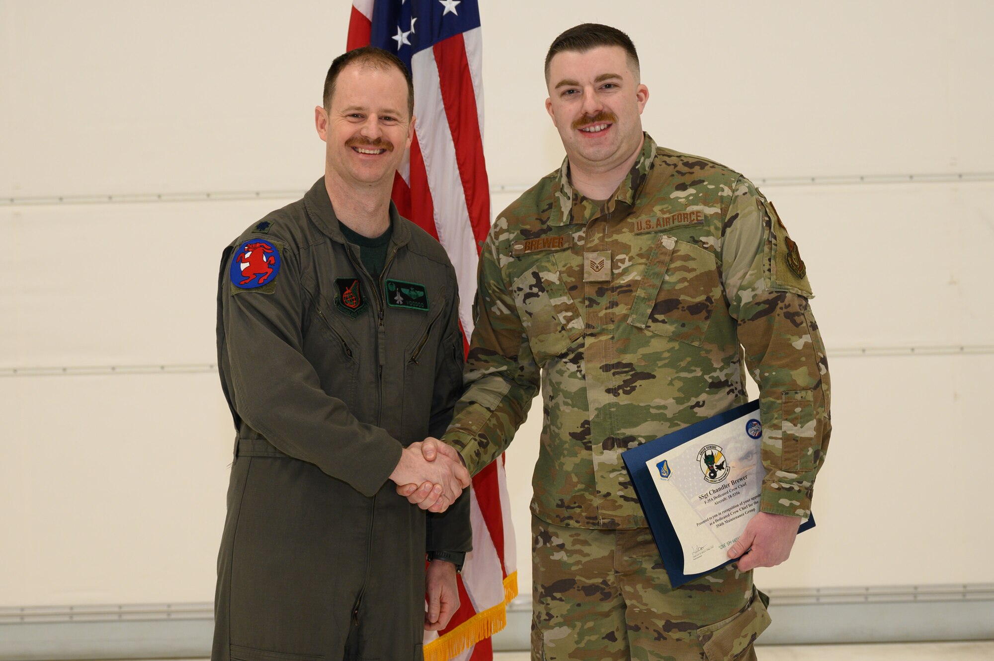 U.S. Air Force Lt. Col. Ryan Worrell, 356th Fighter Squadron commander, poses for a photo with Staff Sgt. Chandler Brewer, a 356th Aircraft Maintenance Unit crew chief, during a ceremony on Eielson Air Force Base, Alaska, Jan. 6, 2023.