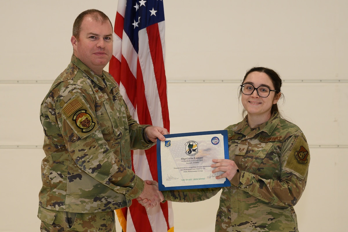 U.S. Air Force Lt. Col. Joseph Langan, 354th Aircraft Maintenance Squadron commander, inducts Staff Sgt. Cerise Lumaye, a 356th Aircraft Maintenance Unit crew chief, during a ceremony on Eielson Air Force Base, Alaska, Jan. 6, 2023.