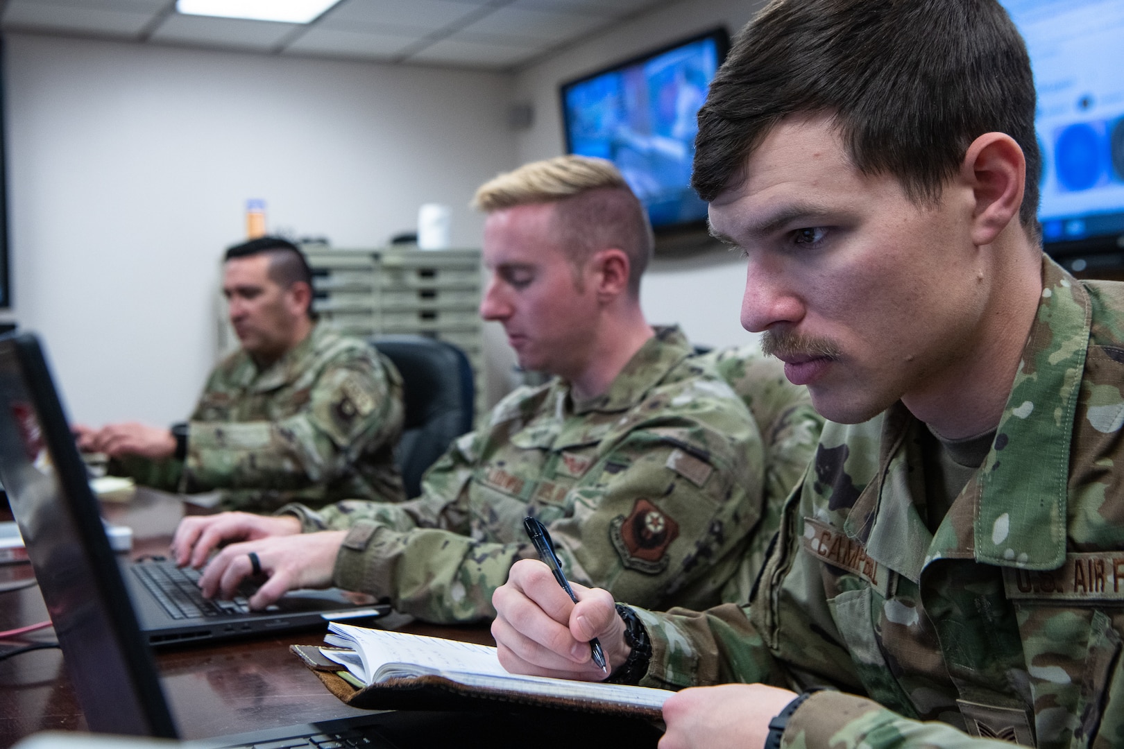 man writes notes at computer