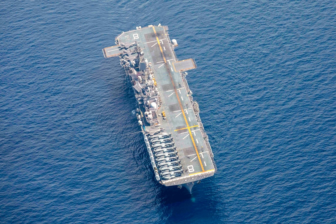 A ship transits a body of water as seen from above.