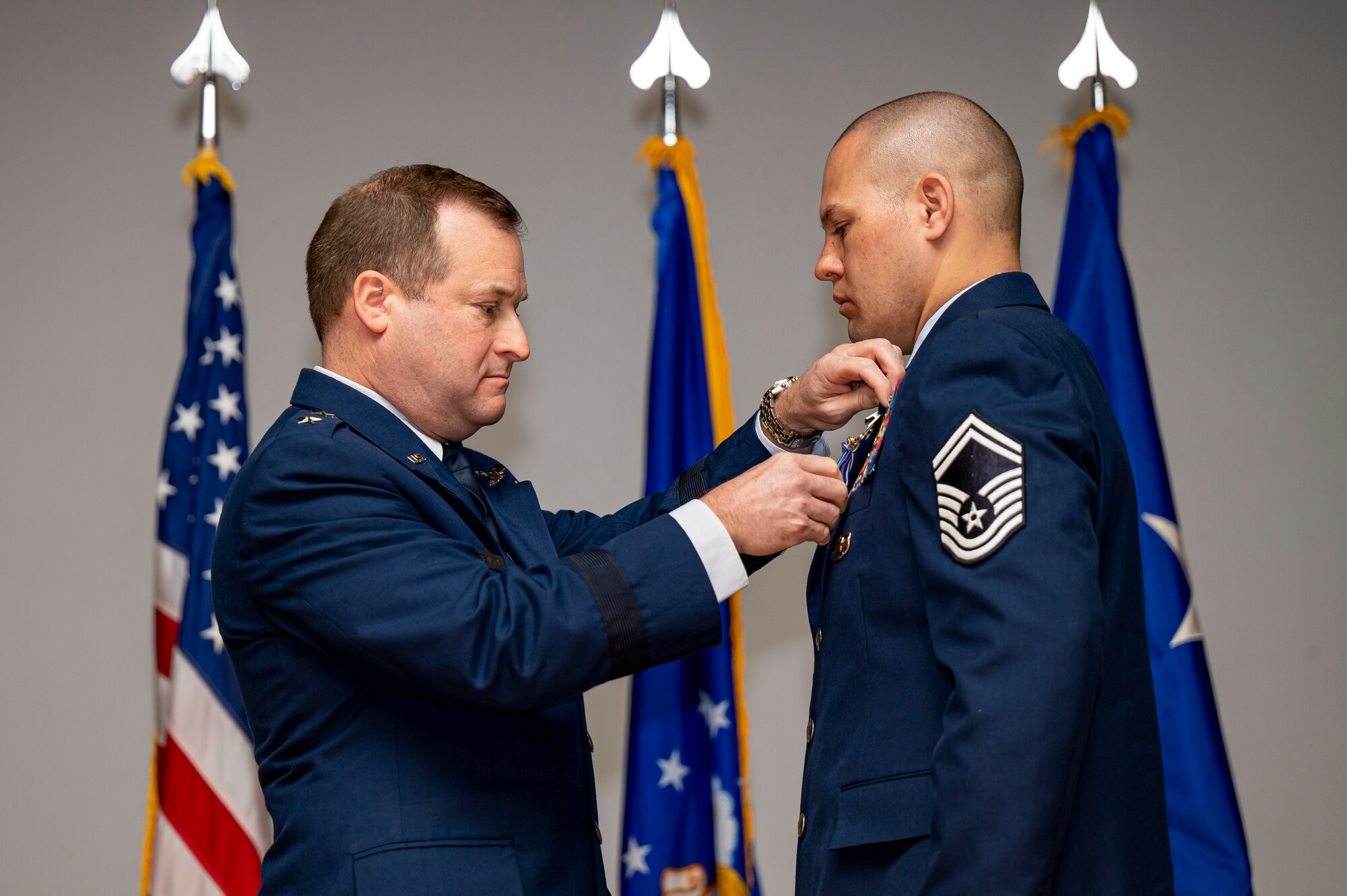 A man pins a medal to another man.