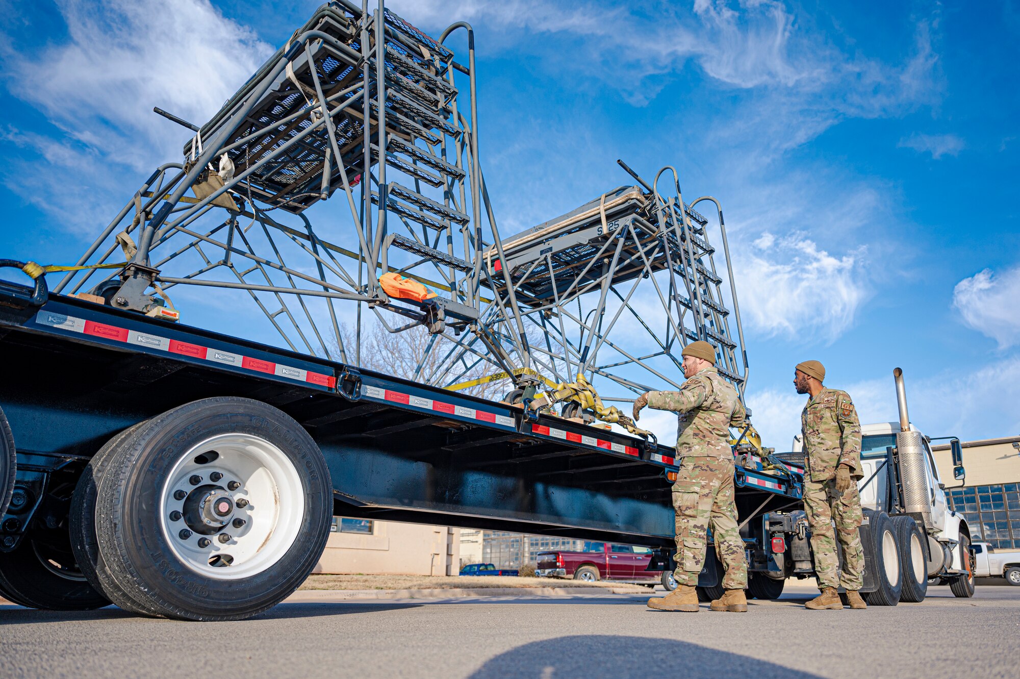 Senior Airman Luis Torres-Santos, 7th Logistic Readiness Squadron ground transportation support operator, left, and Staff Sgt. Tarvorous Mathews, 7th LRS ground transportation specialist, inspect cargo straps holding two B-5 aircraft maintenance stands at Dyess Air Force Base, Texas, Jan. 6, 2023. Airmen assigned to the 7th LRS and 7th Equipment Maintenance Squadron worked together to transport the two maintenance stands to fulfill a short notice tasking. (U.S. Air Force photo by Senior Airman Colin Hollowell)