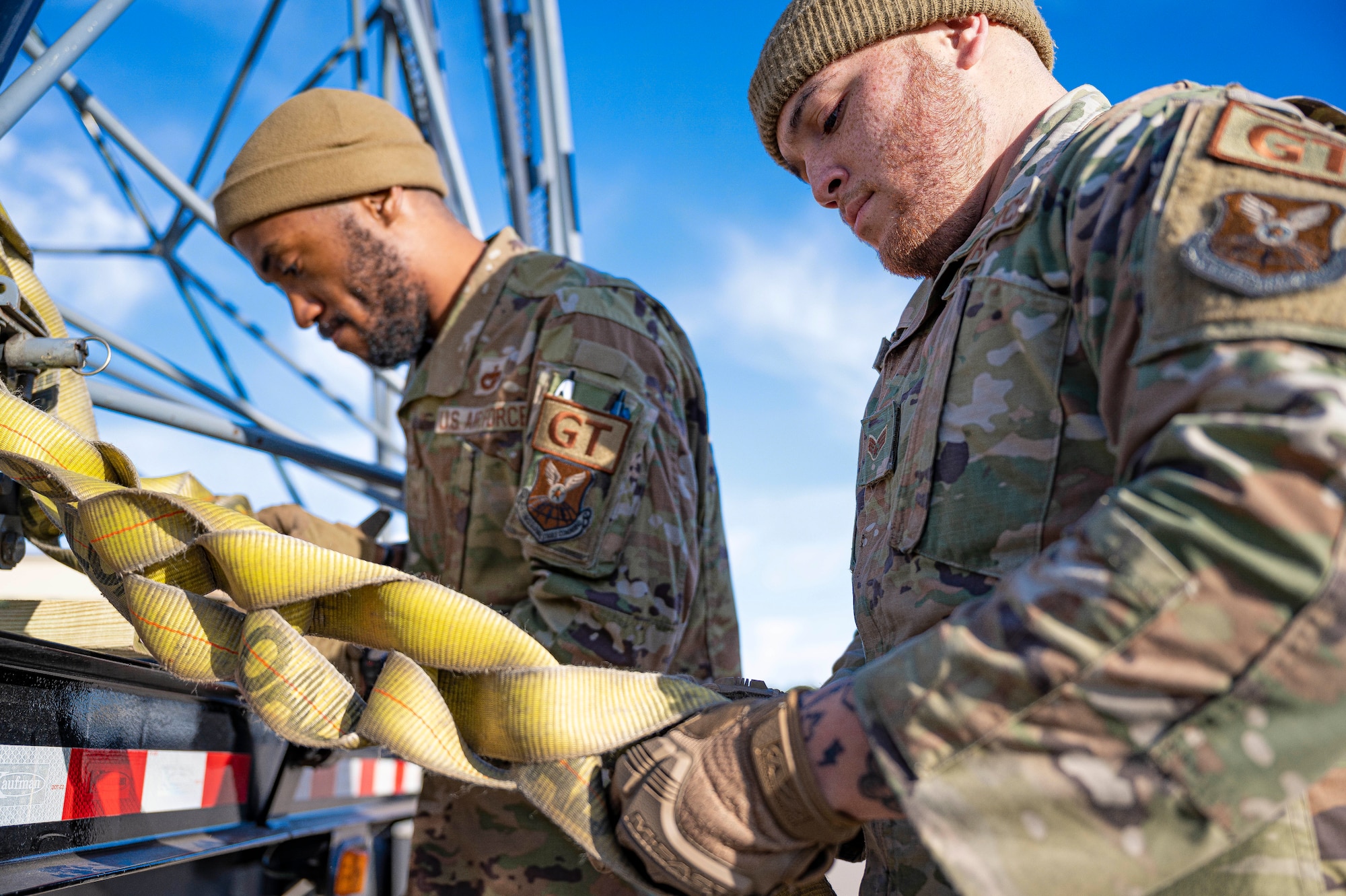 Staff Sgt. Tarvorous Mathews, 7th Logistic Readiness Squadron ground transportation specialist, left, and Senior Airman Luis Torres-Santos, 7th LRS ground transportation support operator, tighten cargo straps holding two B-5 aircraft maintenance stands at Dyess Air Force Base, Texas, Jan. 6, 2023. Airmen assigned to the 7th LRS and 7th Equipment Maintenance Squadron worked together to transport the two maintenance stands to fulfill a short notice tasking. (U.S. Air Force photo by Senior Airman Colin Hollowell)