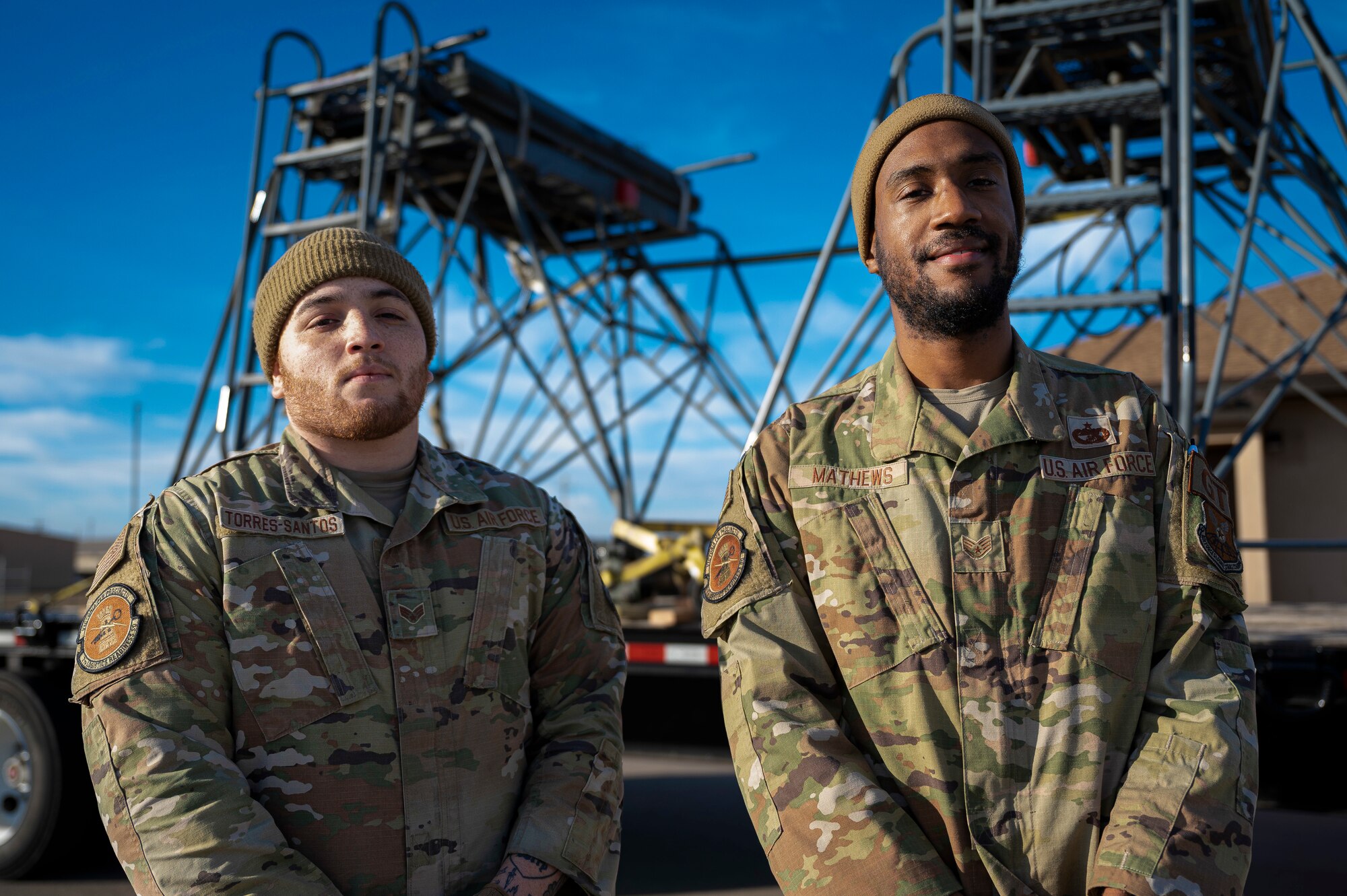 Senior Airman Luis Torres-Santos, 7th Logistic Readiness Squadron ground transportation support operator, left, and Staff Sgt. Tarvorous Mathews, 7th LRS ground transportation specialist, pose for a photo in front of two B-5 aircraft maintenance stands at Dyess Air Force Base, Texas, Jan. 6, 2023. Airmen assigned to the 7th LRS and 7th Equipment Maintenance Squadron worked together to transport the two maintenance stands to fulfill a short notice tasking. (U.S. Air Force photo by Senior Airman Colin Hollowell)