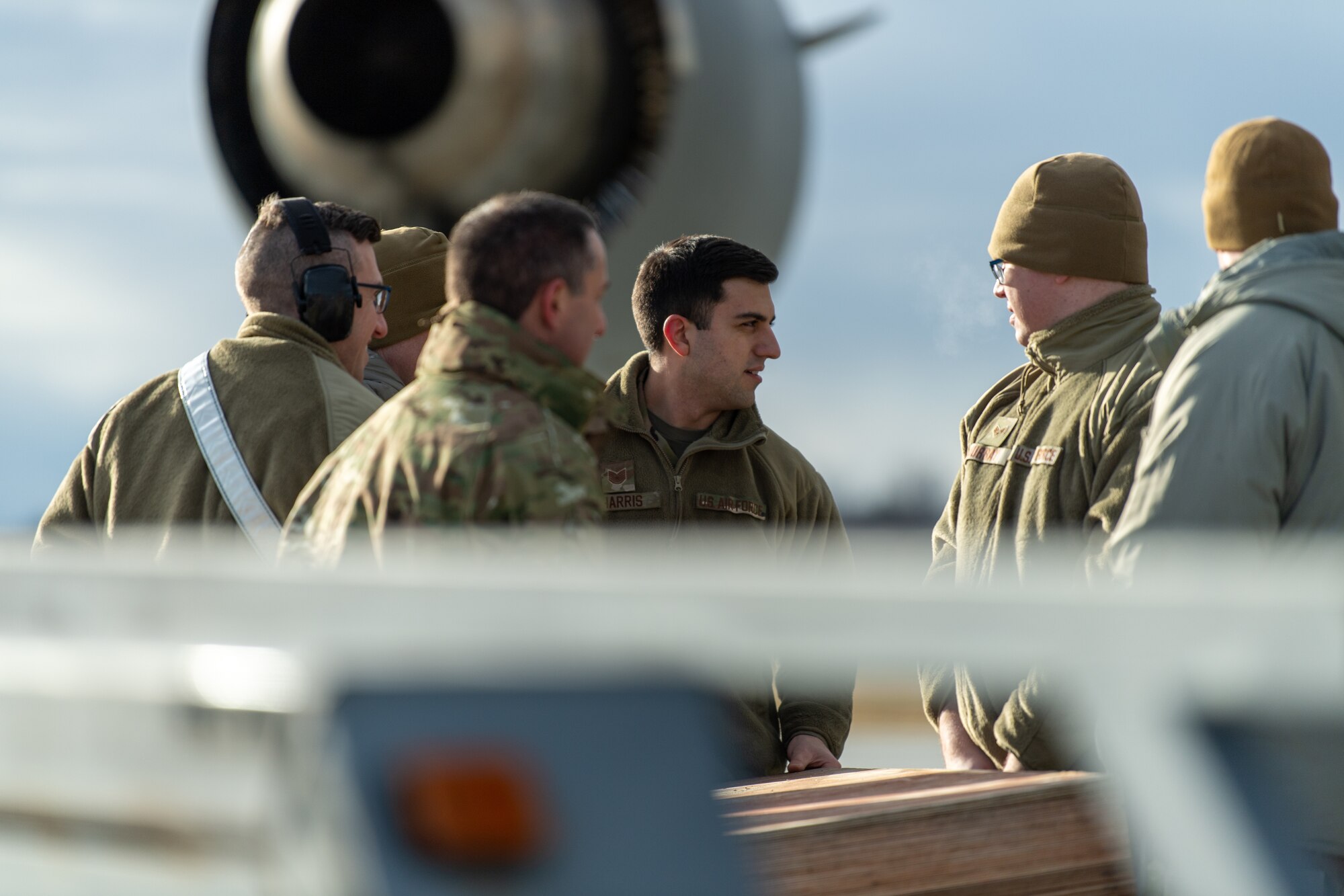 Photo of Airmen from the Vermont Air National Guard's 158th Aircraft Maintenance Squadron, along with Airmen from the New York ANG's 105th Airlift Wing, Stewart Air National Guard Base in Newburgh, New York, position wooden ramps to assist with loading equipment onto a C-17 Globemaster III aircraft at the Vermont Air National Guard Base, South Burlington, Vermont, Dec. 4, 2022.