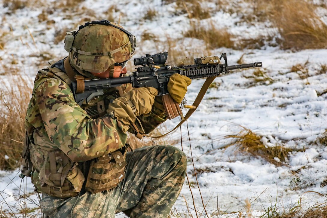 A soldier shoots a rifle.
