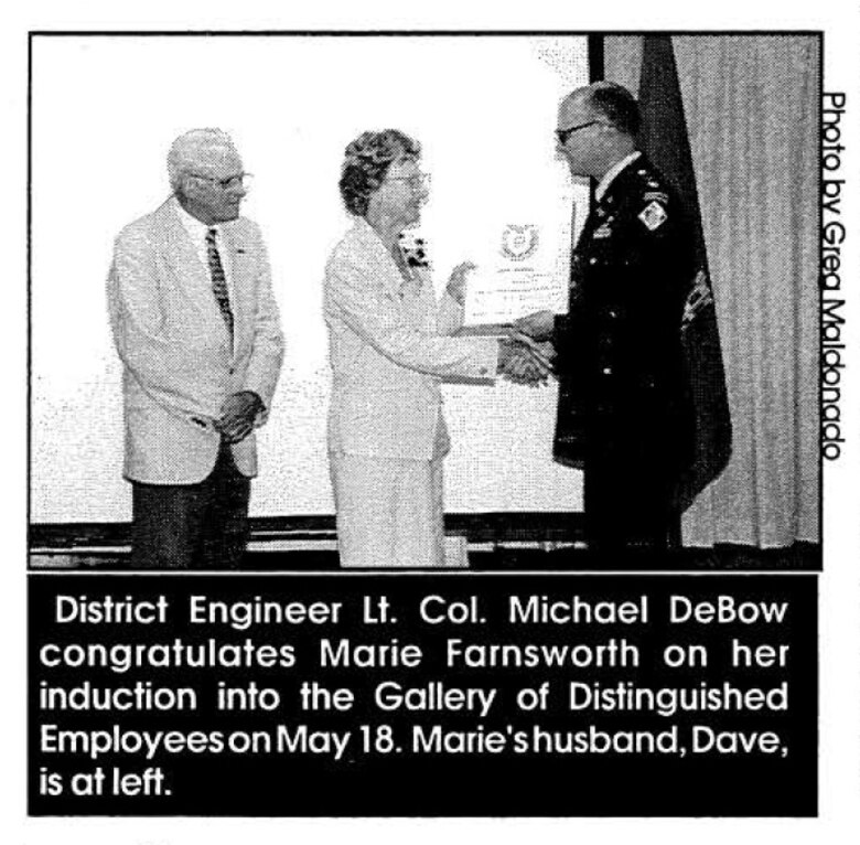 District Engineer Lt. Col. Michael DeBow congratulates Marie Farnsworth on her induction into the Gallery of Distinguished Employees on May 18. Marie's husband, Dave, is at left.