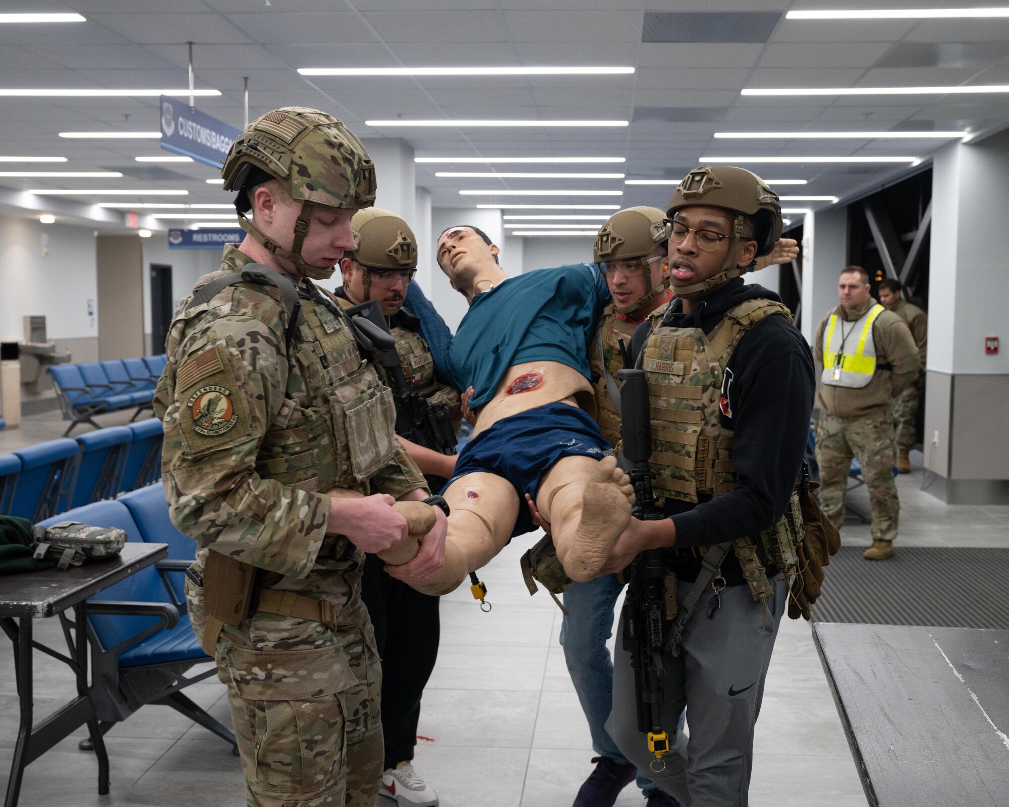 Four Security Forces airman carry out a mannequin during training