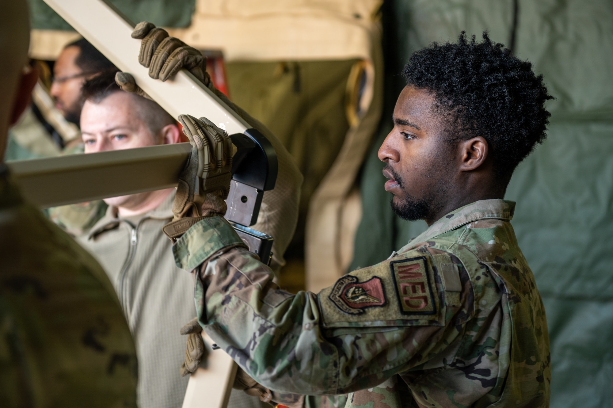U.S. Air Force Senior Airman Bryson Lyles, 51st Operational Medical Readiness Squadron dental lab technician, moves the frame leg of a Tent Kit 2 (TK2) expeditionary medical support shelter into position during a training event at Osan Air Base, Republic of Korea, Jan. 12, 2023.