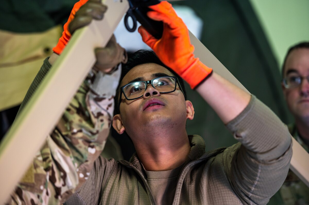 U.S. Air Force Staff Sgt. Kiven Alfelor, 51st Medical Support Squadron war reserve material maintenance craftsman, adjusts the frame coupling of a Tent Kit 2 (TK2) expeditionary medical support shelter during a training event at Osan Air Base, Republic of Korea, Jan. 12, 2023.