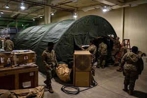 U.S. Air Force Airmen from the 51st Medical Group assemble the frame of a Tent Kit 2 (TK2) expeditionary medical support shelter as part of a training event at Osan Air Base, Republic of Korea, Jan. 12, 2023.