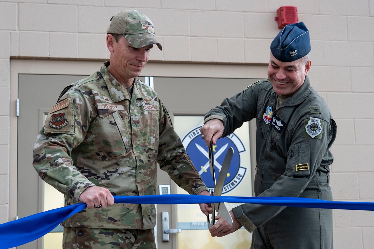 Colonel James Hewitt, 688th Cyberspace Wing commander, left, and Colonel Mathew Bradley, 53rd Wing commander, right, cut the ribbon officially opening the new 53rd Computer Systems Squadron building at Nellis Air Force Base, Nevada, Jan 10. 2022. The 53rd CSS is a geographically separated unit from Eglin Air Force Base, Florida. (U.S. Air Force Photo By Airman First Class Bell)